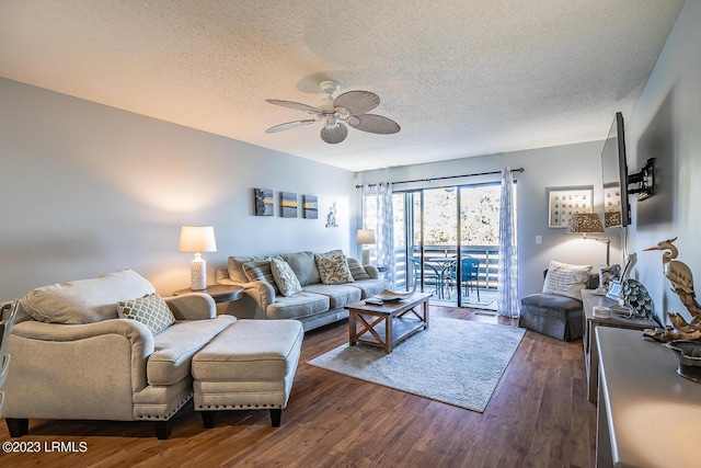 living room with ceiling fan, dark hardwood / wood-style floors, and a textured ceiling