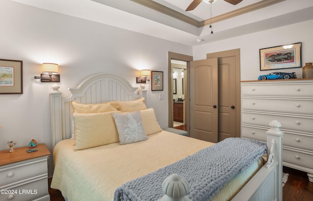 bedroom with ensuite bath, dark wood-type flooring, ornamental molding, and ceiling fan