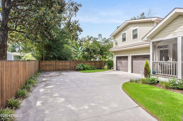 view of home's exterior with a garage and a sunroom