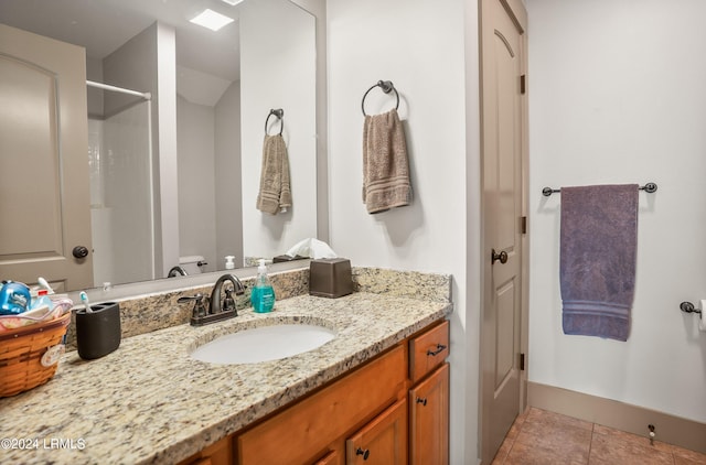 bathroom with walk in shower, tile patterned floors, toilet, and vanity