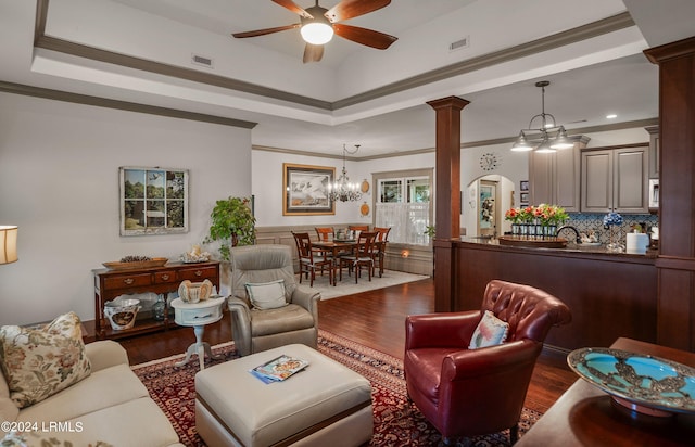 living room with crown molding, ceiling fan, dark hardwood / wood-style flooring, and ornate columns