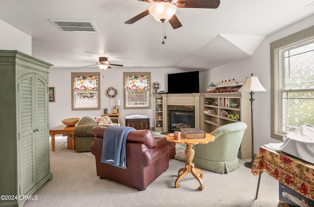 carpeted living room featuring ceiling fan, lofted ceiling, and a high end fireplace