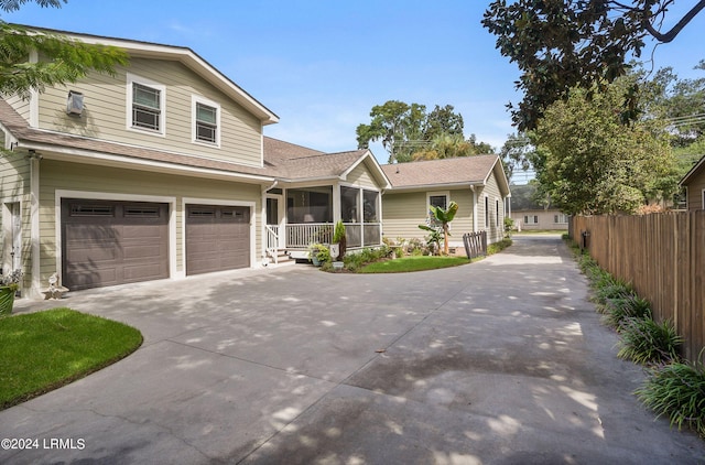 view of front of home featuring a garage and a sunroom