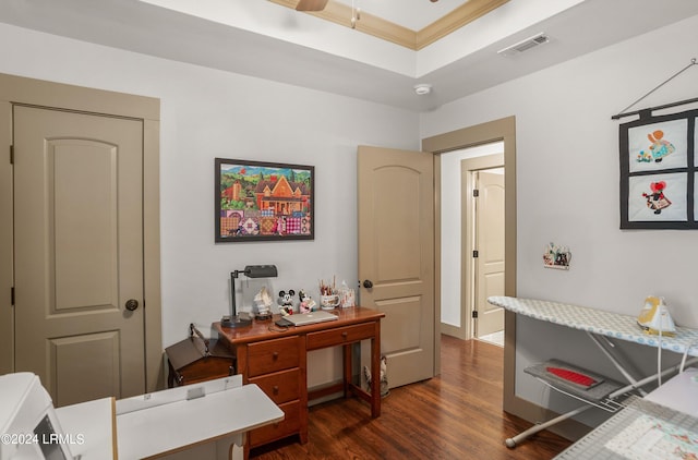 office area with dark hardwood / wood-style flooring, ornamental molding, and a raised ceiling