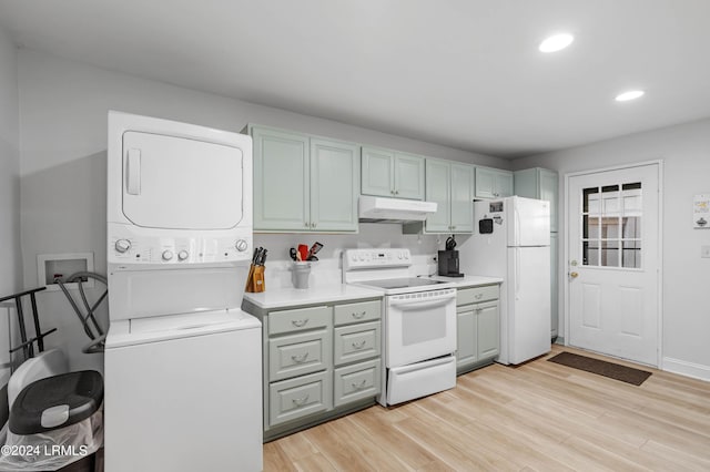 kitchen with white appliances, stacked washer / drying machine, and light wood-type flooring