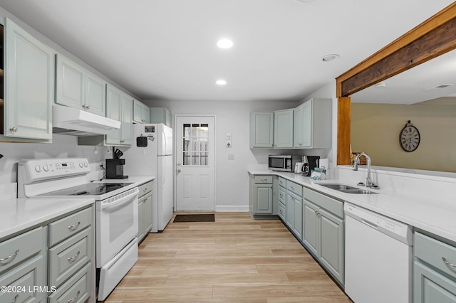 kitchen with white appliances, gray cabinets, sink, and light hardwood / wood-style flooring