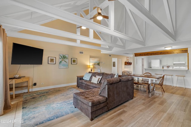 living room with ceiling fan, high vaulted ceiling, and light hardwood / wood-style floors