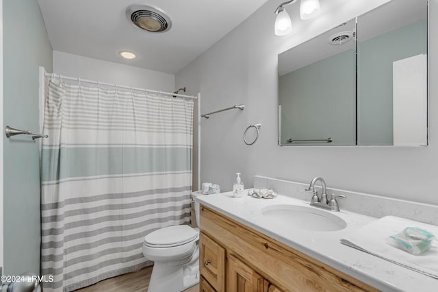 bathroom with vanity, wood-type flooring, toilet, and walk in shower