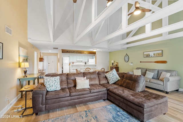 living room with a high ceiling and light hardwood / wood-style flooring