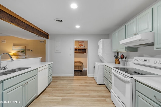 kitchen with beamed ceiling, white appliances, and sink