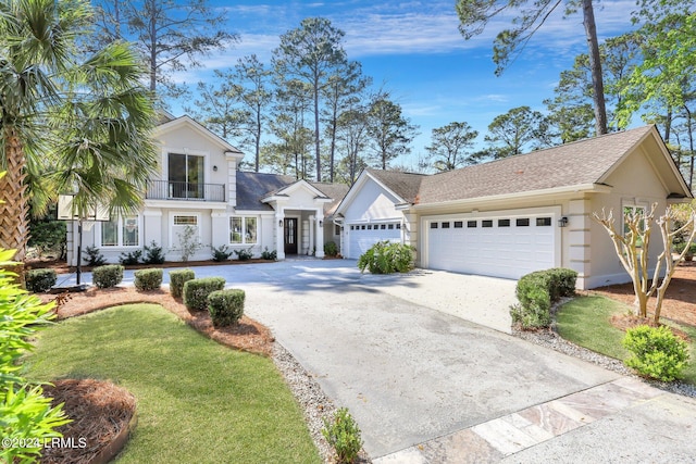 view of front of home with a garage, a balcony, and a front lawn