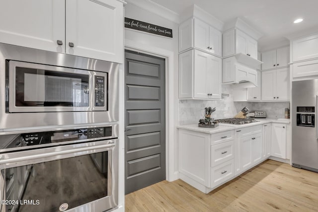 kitchen featuring stainless steel appliances, white cabinets, and light wood-type flooring