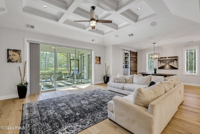 living room featuring coffered ceiling, light hardwood / wood-style floors, and a barn door