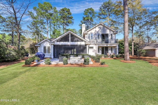 back of property with a balcony and a lawn