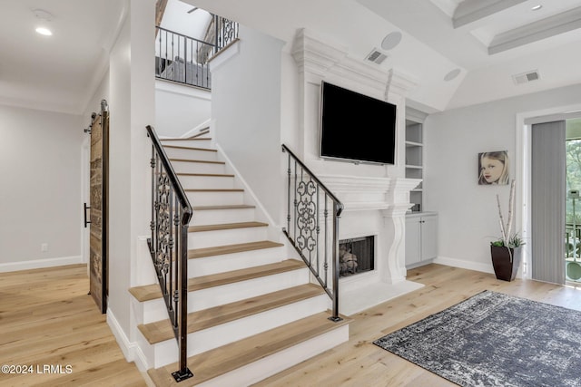 stairs with hardwood / wood-style floors and a barn door