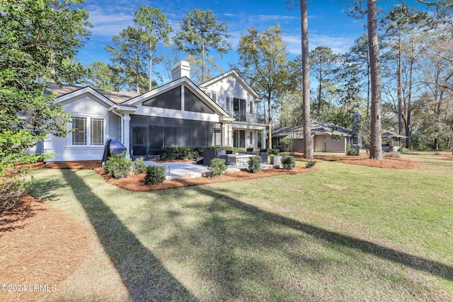 rear view of house featuring a patio, a balcony, and a yard