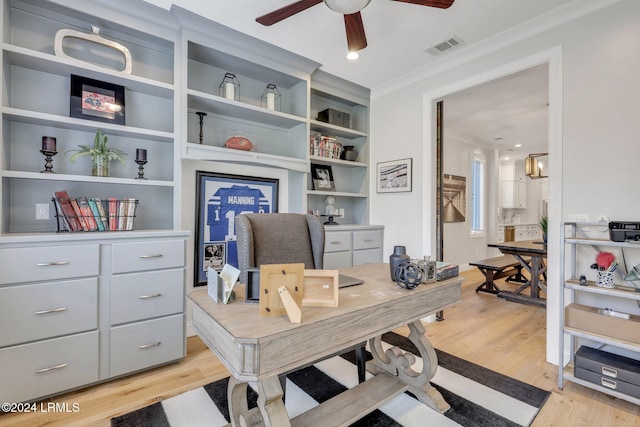 office featuring ornamental molding, built in features, ceiling fan, and light hardwood / wood-style flooring