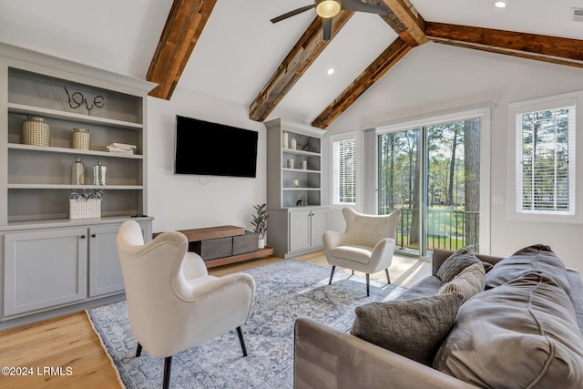 living room featuring lofted ceiling with beams, light hardwood / wood-style floors, and ceiling fan