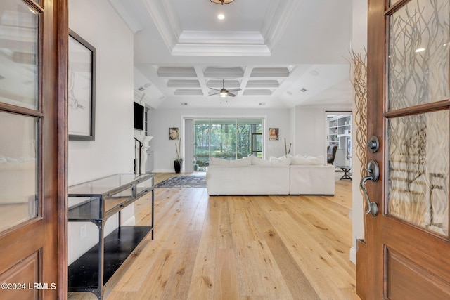 living room with crown molding, light hardwood / wood-style flooring, ceiling fan, coffered ceiling, and beamed ceiling