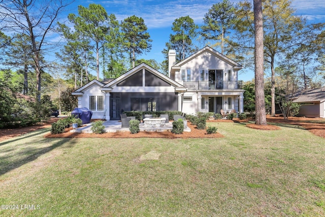 view of front of home with a balcony and a front lawn