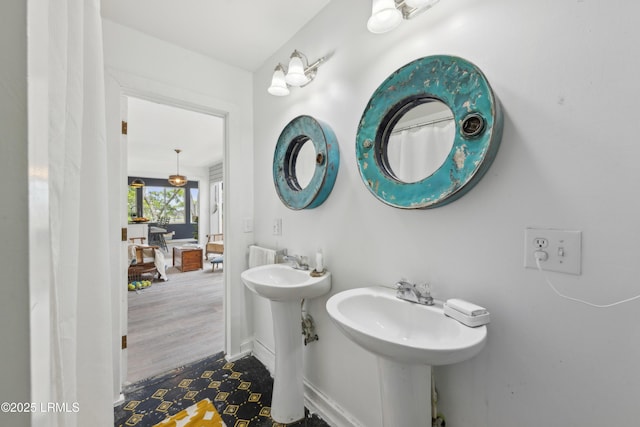 full bath featuring a sink and baseboards