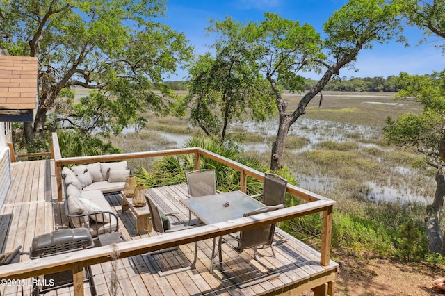 deck featuring an outdoor living space, outdoor dining space, and a water view