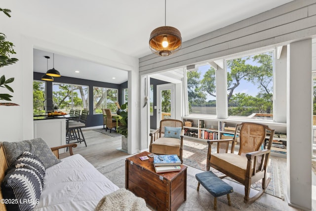sunroom with recessed lighting, plenty of natural light, and wood finished floors