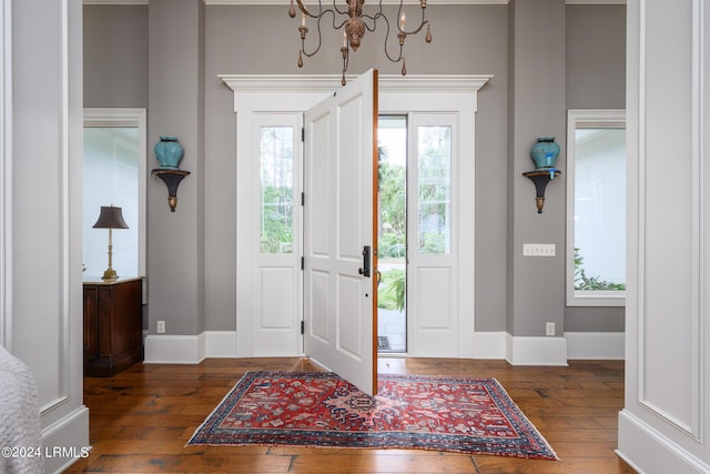 foyer featuring plenty of natural light, dark hardwood / wood-style floors, and a chandelier