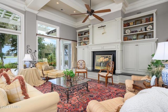 living room featuring built in shelves, ornamental molding, and ceiling fan