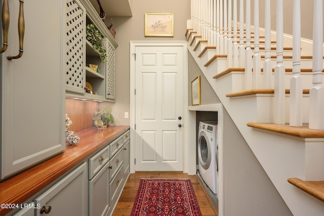 laundry room featuring cabinets, dark hardwood / wood-style floors, and washer / dryer