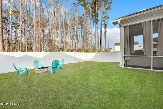 view of yard with a sunroom and an outdoor fire pit