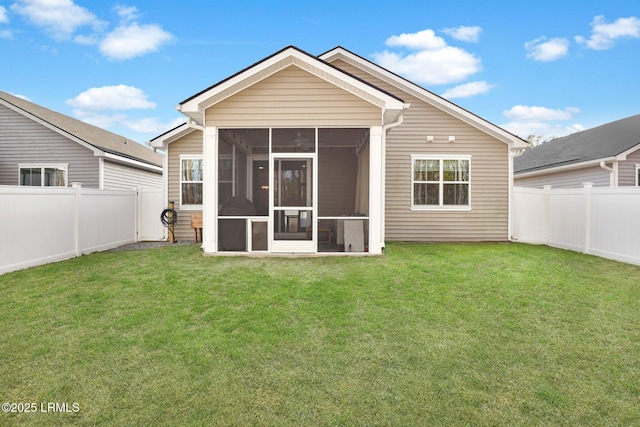 rear view of house featuring a yard and a sunroom