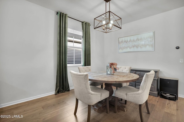 dining area featuring a notable chandelier and light wood-type flooring