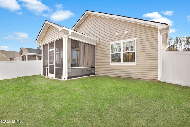 rear view of property with a yard and a sunroom