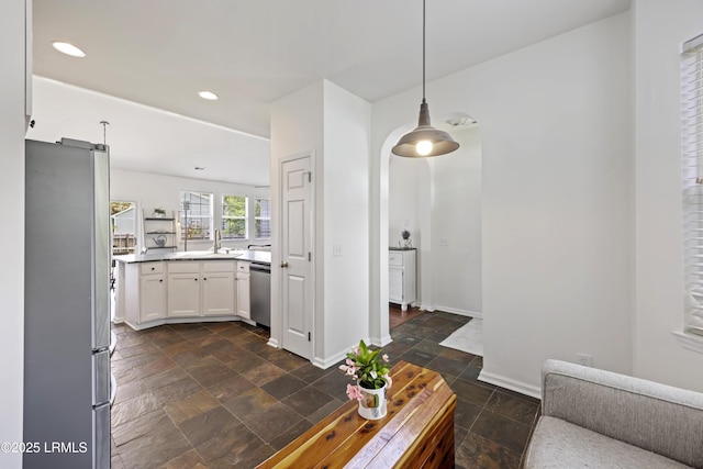 1470 Ashley Gardens Blvd, Charleston, SC 29414 - kitchen with appliances with stainless steel finishes, stone tile floors, white cabinets, a sink, and decorative light fixtures