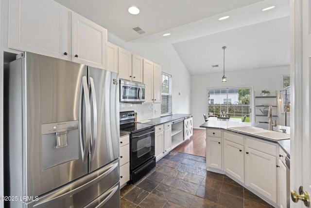 1470 Ashley Gardens Blvd, Charleston, SC 29414 - kitchen with stainless steel appliances, a sink, lofted ceiling, stone tile floors, and decorative backsplash