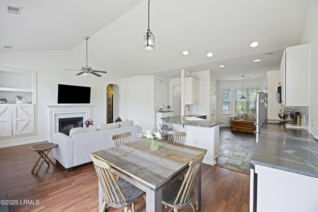1470 Ashley Gardens Blvd, Charleston, SC 29414 - dining space featuring arched walkways, a fireplace, ceiling fan, recessed lighting, and lofted ceiling