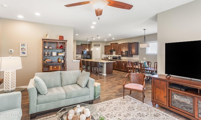 living room with sink, wood-type flooring, and ceiling fan