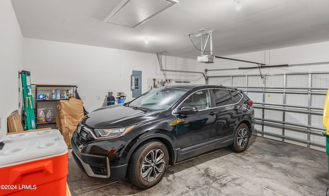 garage with a garage door opener and electric panel