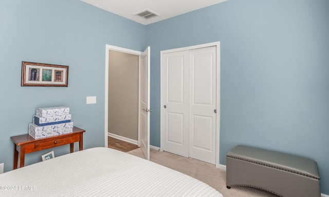 bedroom with light carpet and a closet