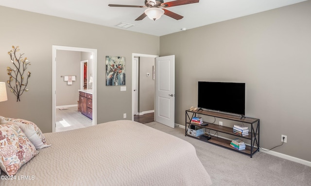 carpeted bedroom with ceiling fan and ensuite bath