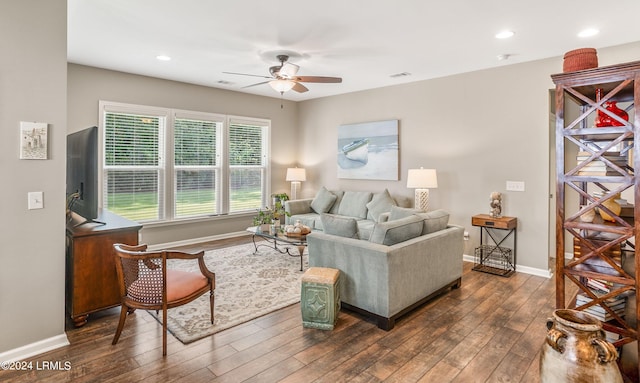 living room featuring ceiling fan and dark hardwood / wood-style floors