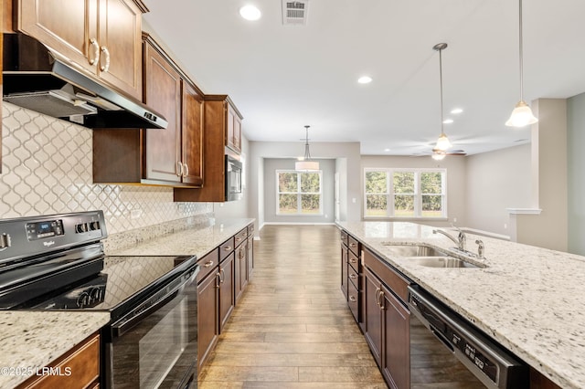 59 Gatewood Ln, Bluffton, SC 29910 - kitchen with black appliances, under cabinet range hood, light wood-style flooring, tasteful backsplash, and pendant lighting
