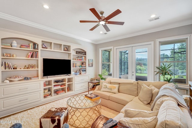 living room with built in features, ornamental molding, french doors, and ceiling fan