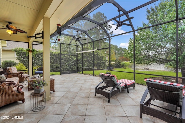 view of patio featuring ceiling fan and glass enclosure