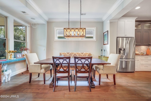 dining area with crown molding, hardwood / wood-style floors, and breakfast area