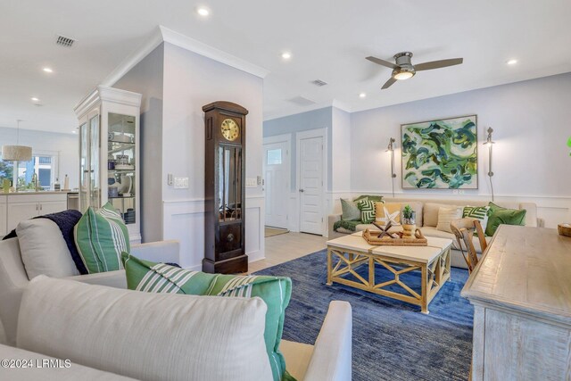 living room with ceiling fan, ornamental molding, and hardwood / wood-style floors