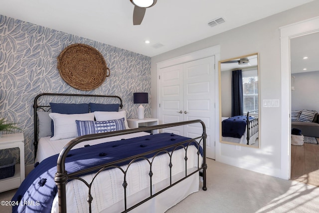 carpeted bedroom featuring ceiling fan and a closet