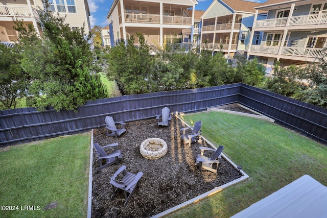 view of community featuring an outdoor fire pit and a lawn