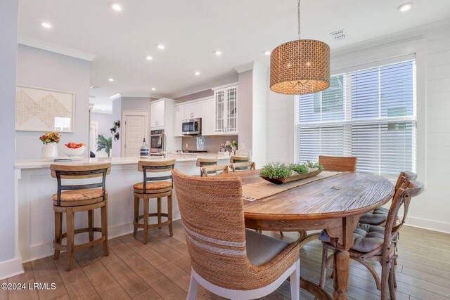 dining room with hardwood / wood-style flooring and ornamental molding